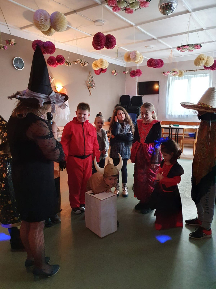 Dzieci w kostiumach biorą udział w konkursie podczas zabawy Halloweenowej