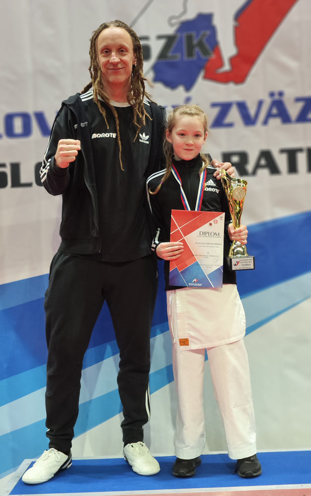 Mężczyzna z dziewczynką, która trzyma medal stoją na podium